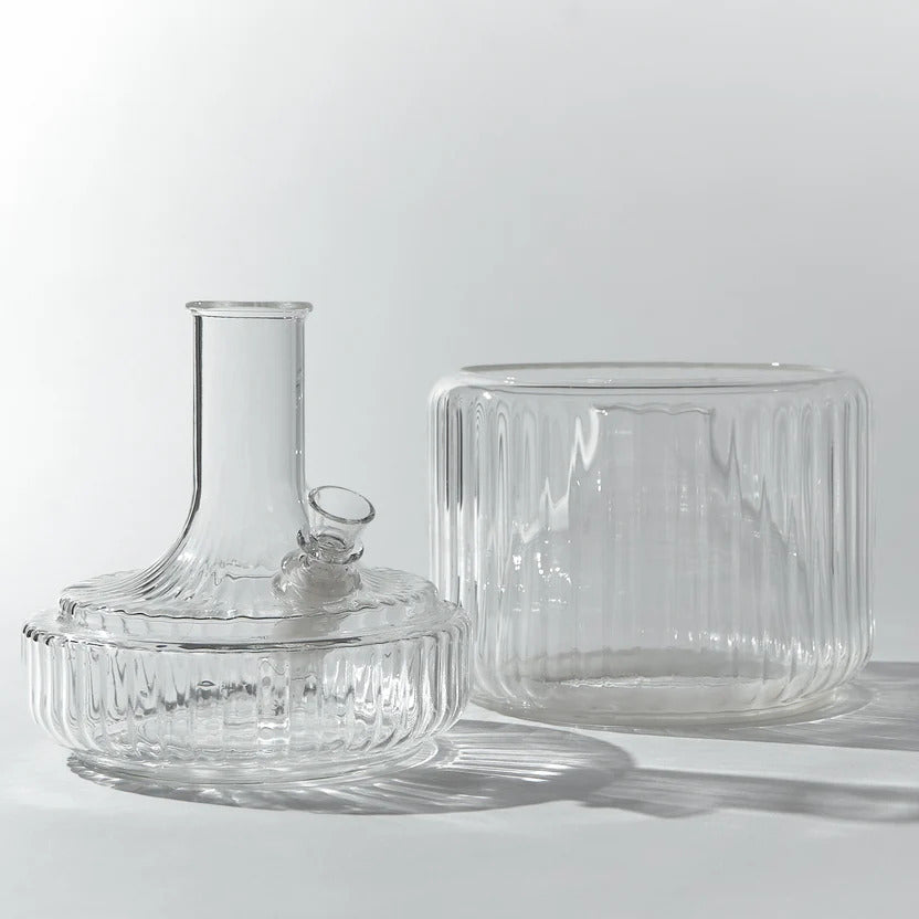 A sculptural two-piece clear glass vase bong displayed against a white background, with its removable top and bowl positioned to show form and function. This vase-style bong offers a clean, modern silhouette and is a sophisticated alternative to typical water pipes—ideal for anyone searching for a decorative bong or bud vase.